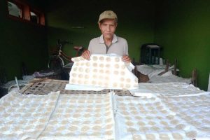 Perajin kerupuk, Zainal Abjad, saat produksi kerupuk yang baru dicetak. (ws4) - Minyak Goreng Langka, Perajin Kerupuk Malang Ini Terpaksa Kecilkan Ukuran