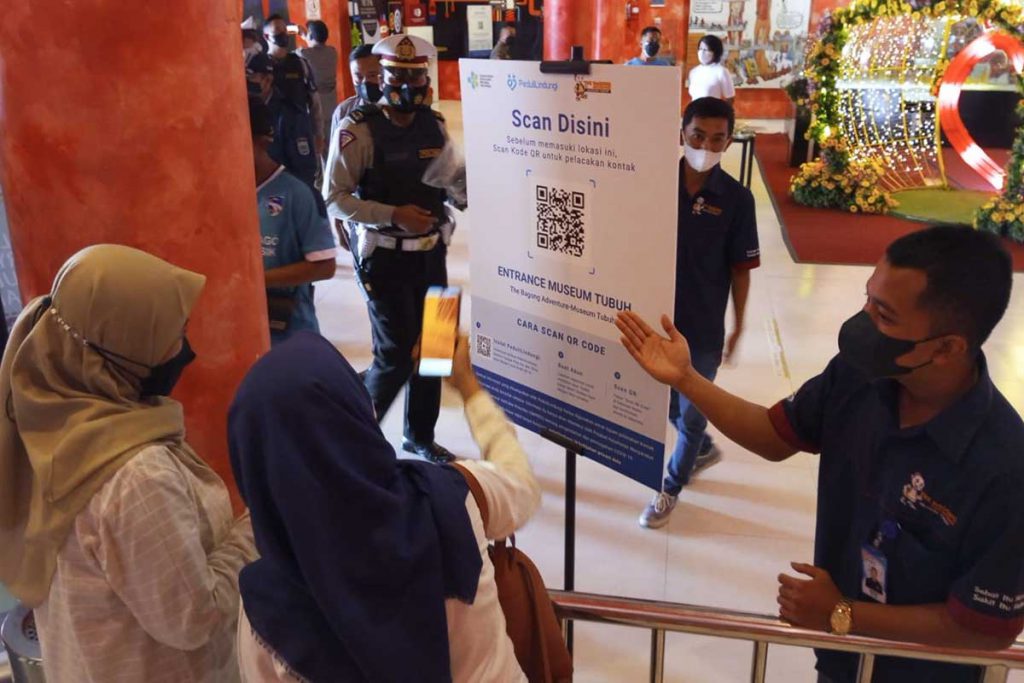 Petugas entrance membantu pengunjung yang akan check in. (ws3) - Libur Imlek di Batu, Pamor Keris Terus Buru Pelanggar Prokes