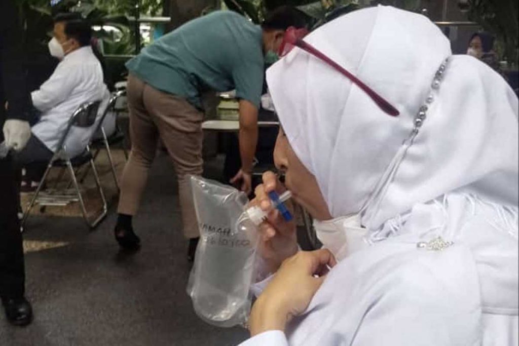 Salah satu meniup kantong plastik untuk diambil sampel nafasnya, dan dideteksi covid-19 atau tidak. (ist) - Deteksi Covid-19, UB Skrining Karyawan dengan UBreath