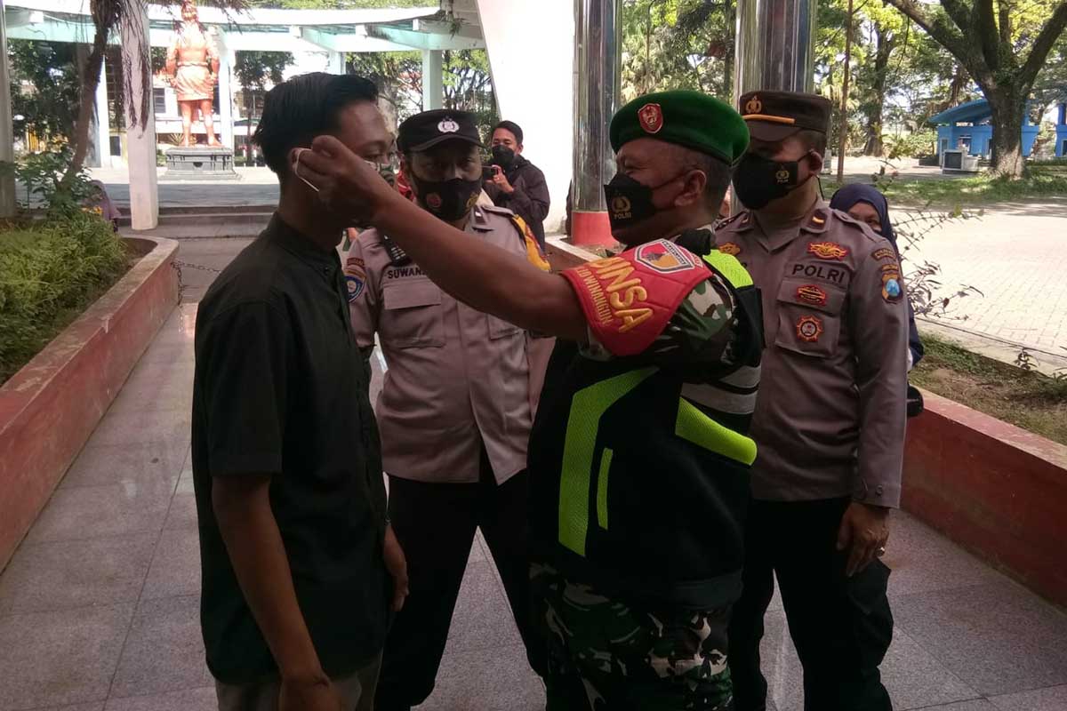 Tim Pamor Keris memberikan masker kepada pengunjung yang kedapatan tak bermasker. (ist) - Tim Pamor Keris Kedungkandang Kawal Operasi Pasar di GOR Ken Arok
