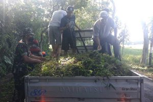 Warga bersama Babinsa mengangkut sampah tanaman liar. (ist) - Warga Tasikmadu Kerja Bakti Antisipasi Banjir