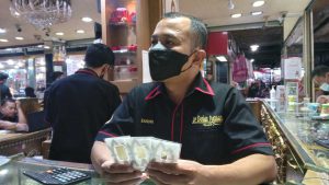 Emas antam ditunjukan salah satu pegawai toko emas di Pasar Besar Kota Malang, Senin (7/3/2022). (bob) - Imbas Perang Rusia-Ukraina, Harga Emas Antam Naik Hampir Rp 100 Ribu