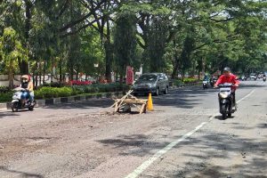 Jalan Veteran diberi tanda kayu untuk mencegah pengendara terjerembab di jalan berlubang. (jaz) - Anggaran Habis, Jalan Berlubang Kota Malang Terancam Tak Bisa Diperbaiki