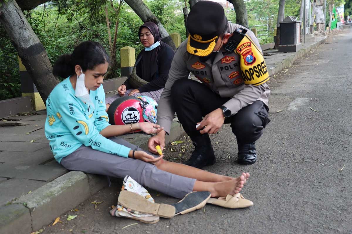 Kapolres Batu, AKBP I Nyoman Yogi Hermawan bantu mengobati korban. (ist) - Berpapasan Dengan Lakalantas, Kapolres Batu Langsung Bantu Obati Korban