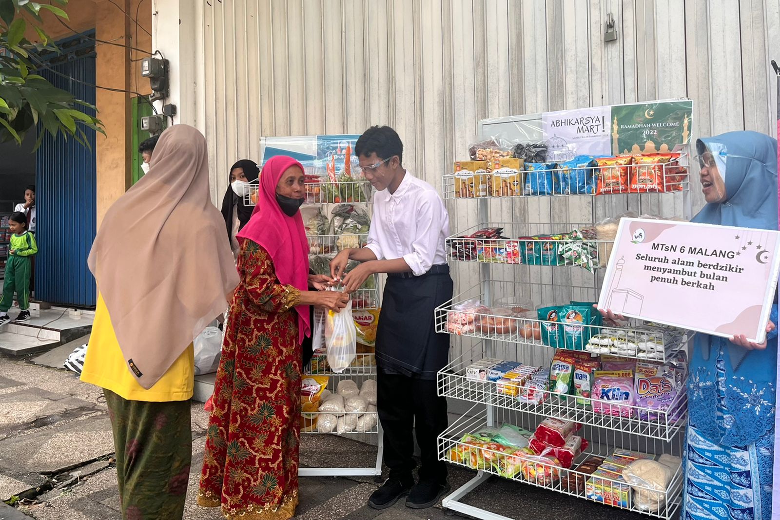 Para siswa MTsN 6 Malang, saat membagikan Sembako kepada para pejalan di sekitar pasar Kepanjen. (ws5) - Gempita Sambut Ramadan, Pelajar MTsN 6 Malang Bagi-Bagi Sembako