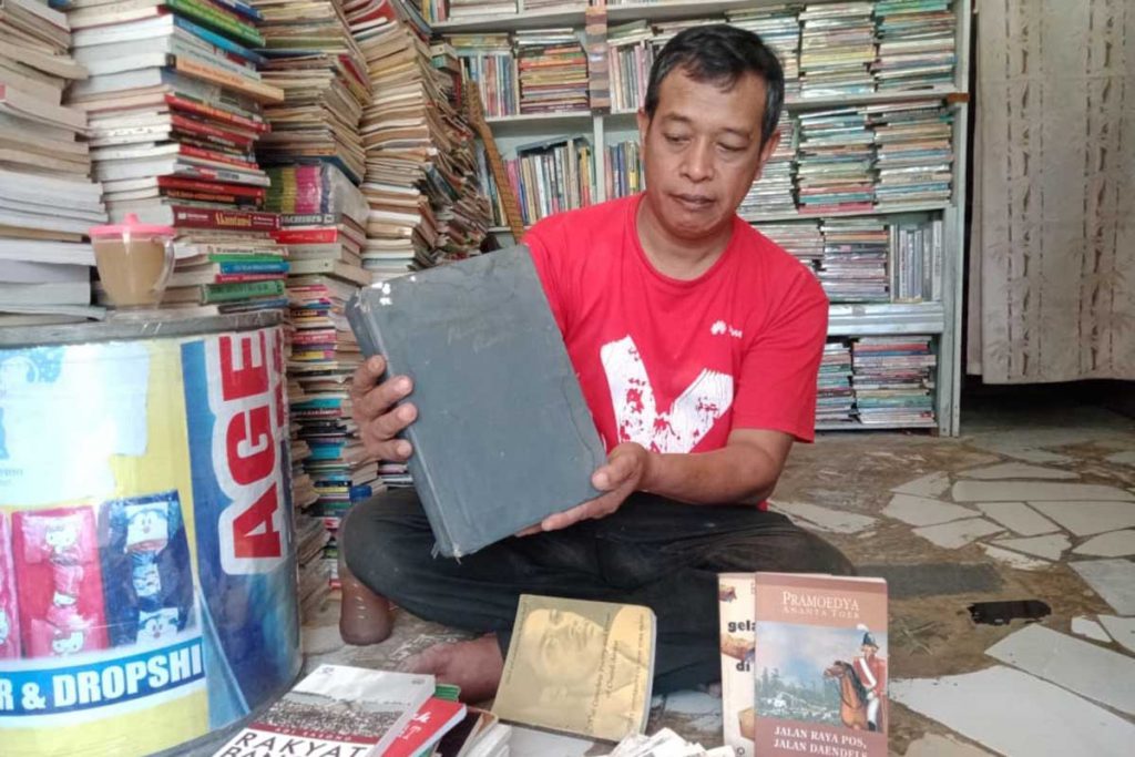 Pemilik Lapak, Ifan Siswono, saat menunjukkan buku sejarah "Setengah Tiang", langka dan unik. (ws4) - Tergerus Teknologi, Begini Kondisi Pedagang Buku Velodrome Kota Malang