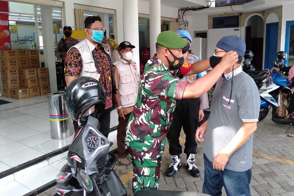 Petugas Pamor Keris memberikan masker kepada pengendara yang melanggar prokes. (ist) - Tingkatkan Kedisiplinan Prokes, Pamor Keris Sasar Warga Kedungkandang