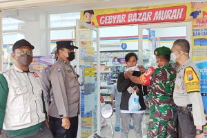 Petugas memakaikan masker pada pengunjung tak bermasker. (ist) - Turunkan Covid-19, Pamor Keris Masif di Wilayah Kedungkandang
