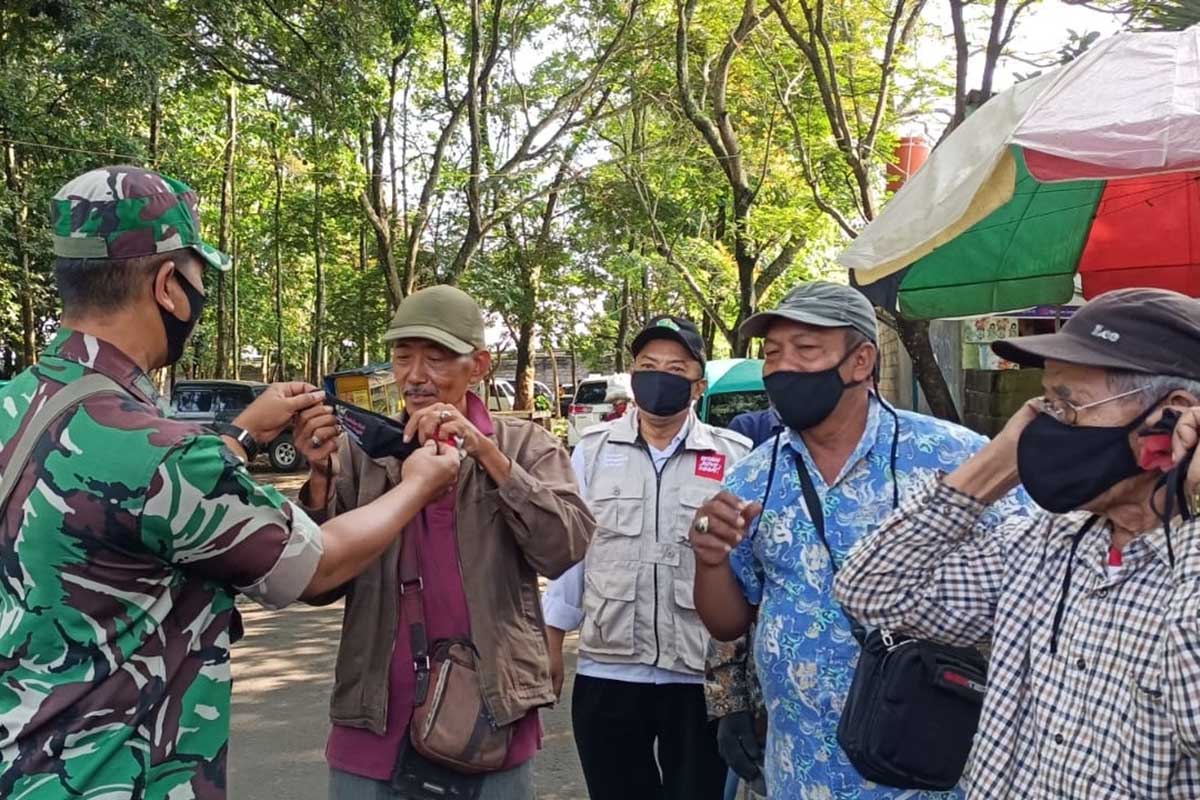Petugas memberikan masker bagi para pelanggar prokes. (ist) - Disiplinkan Prokes, Operasi Pamor Keris Masif di Kota Malang