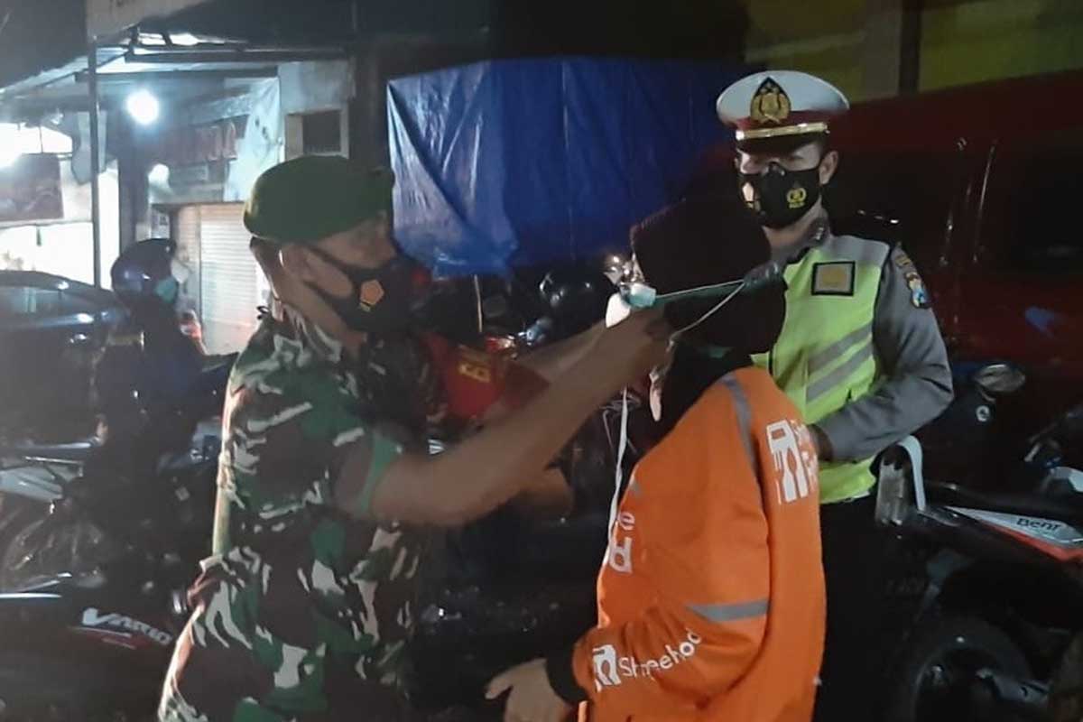 Petugas memberikan masker kepada pengguna jalan yang kedapatan melanggar. (Ist) - Operasi Pamor Keris Sasar Wilayah Kedungkandang
