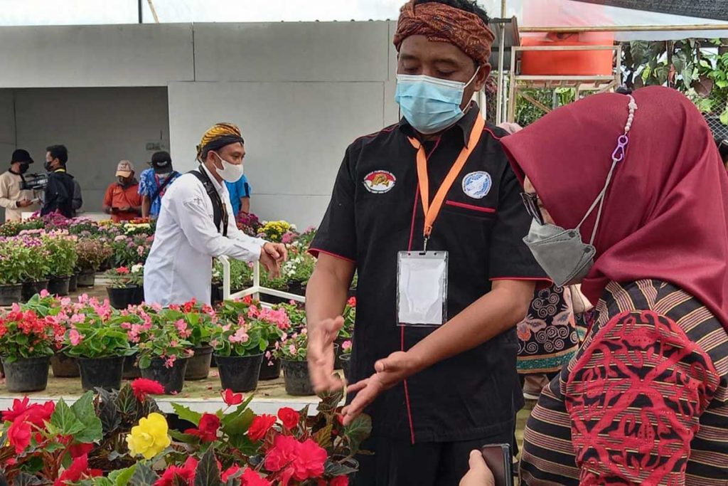 Pramuwisata Batu, sedang memberikan informasi seputar potensi bunga di Desa Sidomulyo. (ist) - Dilibatkan Event W20, Pemandu Wisata Batu Bangga dan Bersyukur