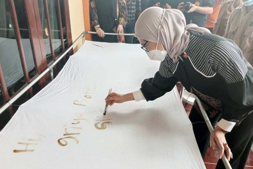 Stafsus Presiden RI Angkey Yudistia, memberikan kenang-kenangan tulisan di selembar kain. (ws3) - Dikunjungi Stafsus Presiden, UMKM Penyandang Disabilitas Bangga dan Terharu
