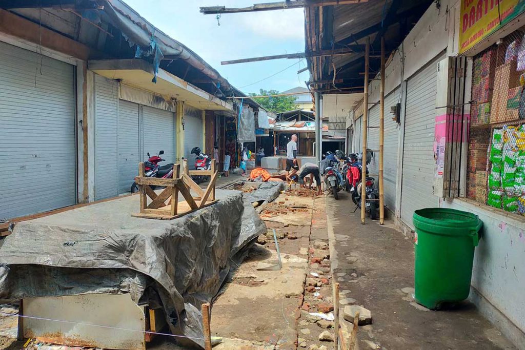 Tukang dan kuli bangunan ketika membersihkan Los pasar Genteng II yang akan direnovasi. (Kuryanto, Memo-X) - Los Pasar Direnovasi, Pedagang Pasar Genteng II Menyambut Gembira