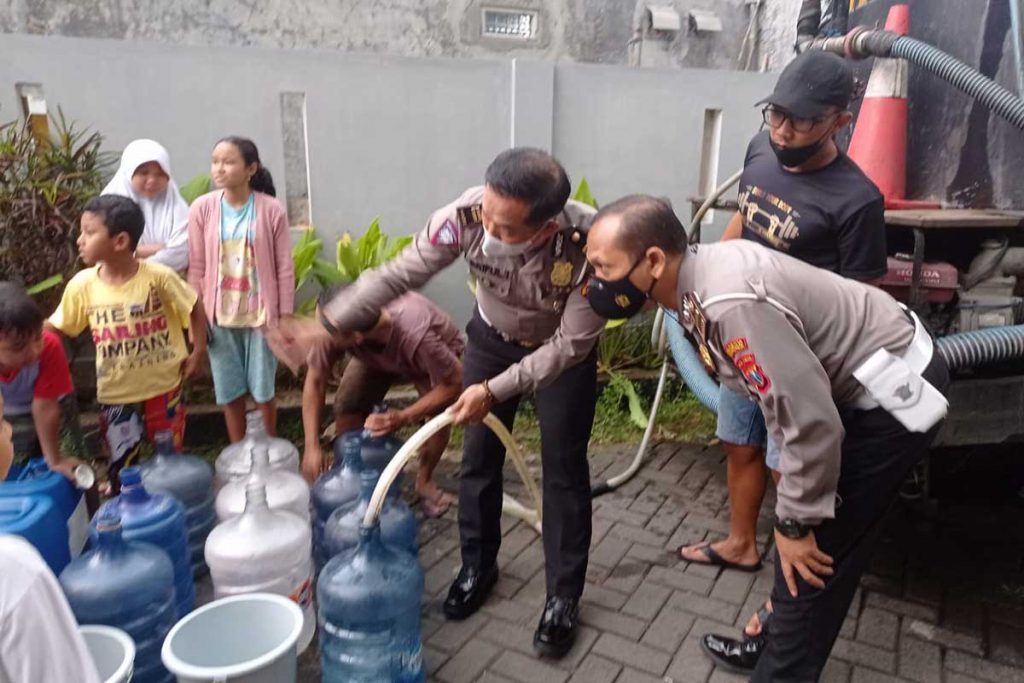 Anggota Polresta Malang Kota terjun membantu mendistribusikan air bersih. (ist) - Layanan Terganggu, Perumda Tugu Tirta Disupport Lintas Jajaran