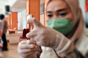 Ilustrasi Nakes sedang mengisi vaksin dari botol ke suntik. (jaz) - Ketersediaan Vaksin di Dinkes Kota Malang Tinggal 400 Dosis