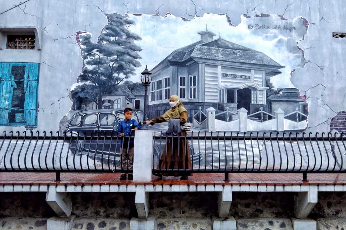 Lokasi favorit pengunjung berfoto di dekat jembatan ada tembok yang bergambar bangunan tempo dulu. (jaz) - Menikmati Suasana Kajoetangan Heritage Kota Malang