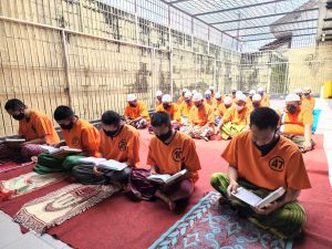 Para tahanan Polres Blitar Kota melaksanakan tadarus membaca Al Quran dari balik jeruji besi. (Memo X/fjr) - 27 Tahanan Polres Blitar Kota Ikuti Pesantren Ramadan