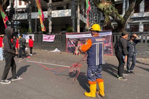 Petugas kebersihan Kota Malang tampak membersihkan sampah yang ditinggalkan massa aksi. (ws5) - Sampah Berserakan Usai Demo, Respons Petugas Kebersihan Malah Terima Kasih