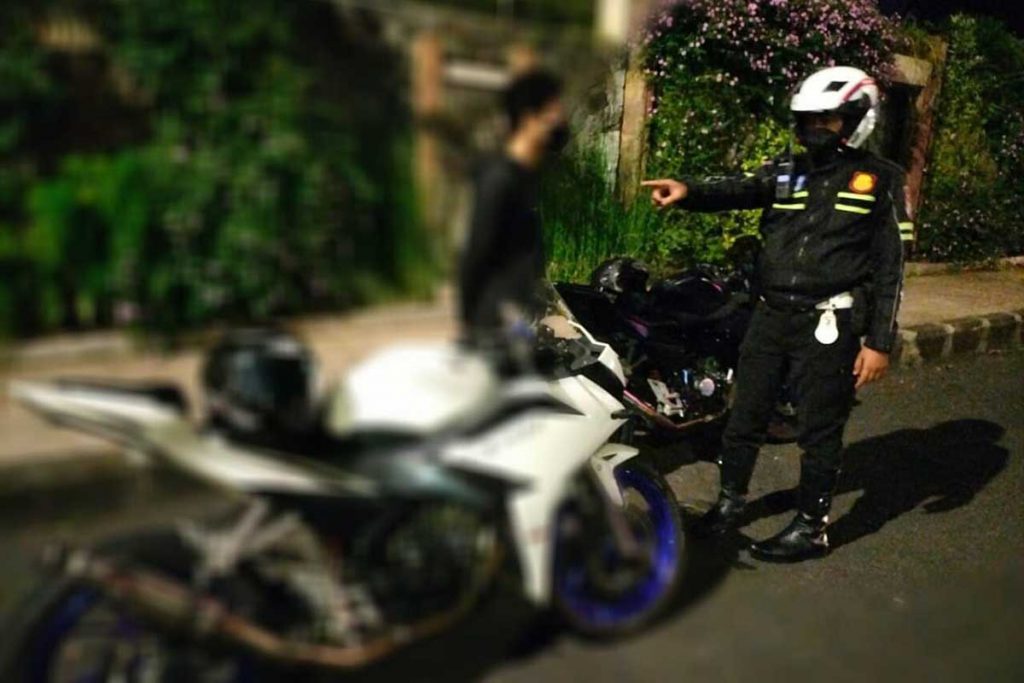 Petugas menghentikan salah seorang pemuda yang disinyalir akan kabur saat didatangi petugas. (ist) - Jaga Kesucian Ramadan, Satlantas Polres Batu Buru Balap Liar - Serta Tertibkan Knalpot Brong