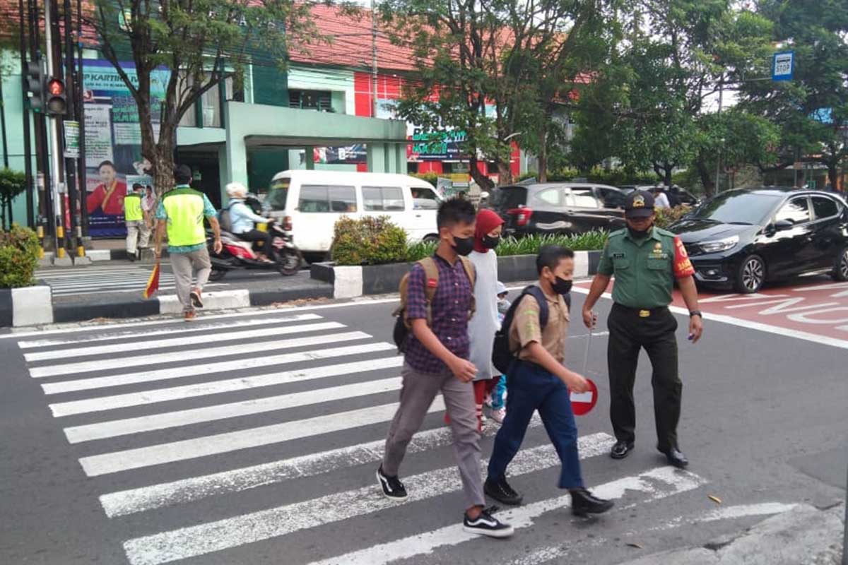 Babinsa Purwodadi bantu penyeberangan siswa SMP Kartika. (ist) - Berikan Rasa Aman, Babinsa Bantu Penyeberangan Anak Sekolah