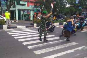 Babinsa Purwodadi memberikan rasa aman siswa SMP KARTIKA IV saat menyeberang jalan. (ist) - Babinsa Berikan Rasa Aman Siswa Menyeberang Jalan