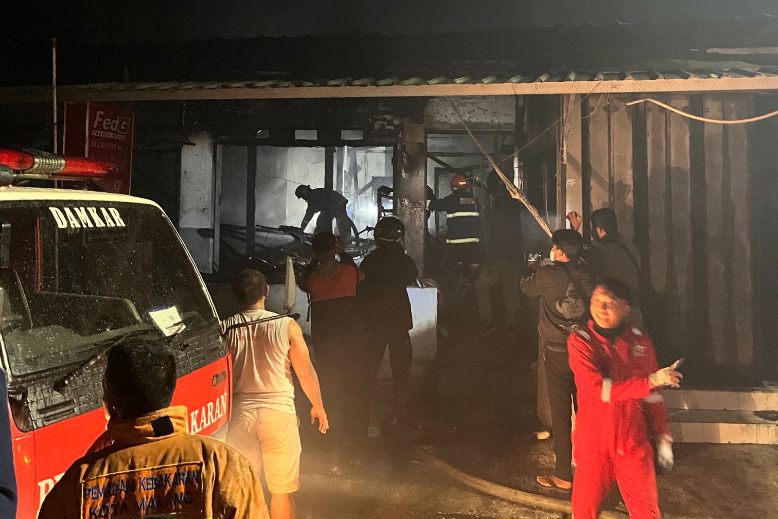 Petugas Pemadam Kebakaran Kota Malang, saat berusaha memadamkan api hingga ke titik nol di lokasi kejadian. (ws5) - Diduga Korsleting Listrik, Bengkel Motor Terbakar Sambar Kos dan Toko Baju
