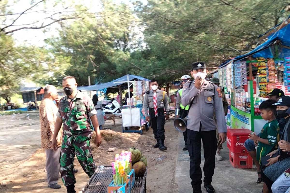Petugas gabungan Operasi Ketupat Semeru 2022 Polres Sampang, saat lakukan operasi taat Prokes di lokasi wisata Pantai Camplong. (ist) - Pantai Camplong Diserbu Wisatawan, Petugas Maksimalkan Pospam Antisipasi Penyebaran Covid-19
