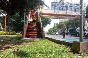 Petugas saat membersihkan Jembatan Penyeberangan Orang (JPO) Alun-Alun Kota Malang. (ist) - DLH Kota Malang Sat-Set Lakukan Pembersihan JPO Alun-Alun