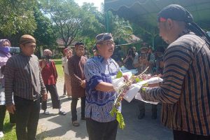 Sesepuh Desa Modangan menyerahkan Manten Kopi kepada Komisaris Kebun Kopi Karanganyar. (leh) - Lestarikan Tradisi, Kebun Kopi Karanganyar Blitar Gelar Manten Kopi
