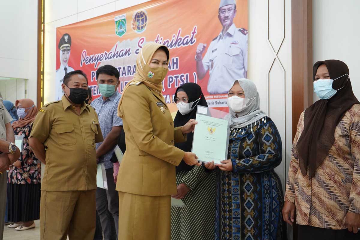 Wali Kota Batu Dewanti Rumpoko menyerahkan sertifikat hak tanah dari program PTSL. (Ist) - 250 Warga Desa Sidomulyo Terima Sertifikat PTSL