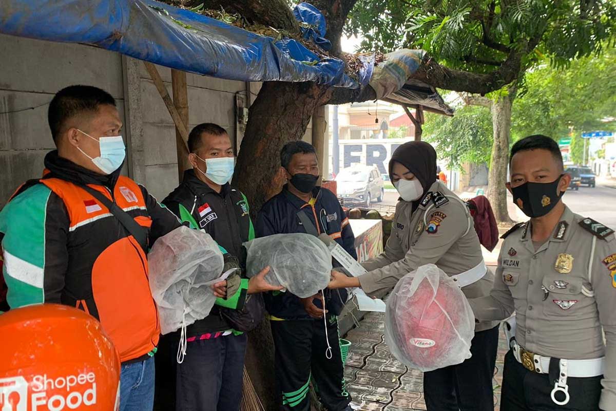 Anggota Satlantas Polres Batu bagi-bagi helm gratis pada warga. (ist) - Jelang Ops Patuh Semeru Polres Batu Bagi-bagi Helm Gratis