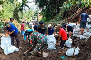 Babinsa Wonokoyo bersama warga bersihkan saluran air. (ist) - Karya Bakti Babinsa Wonokoyo, Bersama Warga Bersihkan Saluran Air