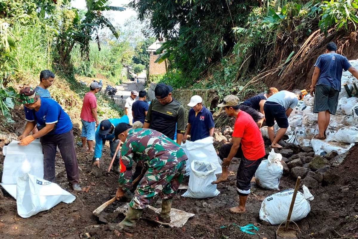 Babinsa Wonokoyo bersama warga bersihkan saluran air. (ist) - Karya Bakti Babinsa Wonokoyo, Bersama Warga Bersihkan Saluran Air