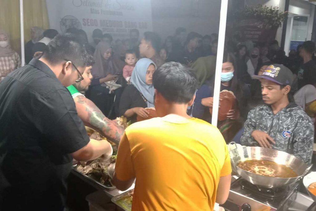 Koh Sandi (baju hitam) ikut turun melayani antrian pembeli Sego Meduro Bang Sad. (ist) - Hadir di Kepanjen, Sego Meduro Bang Sad Sajikan Jeroan Sapi Istimewa