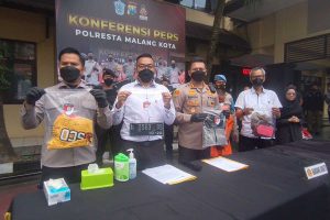 Pihak Polresta Malang Kota menunjukkan barang bukti milik korban dan pelaku. (ws6) - Identitas Mayat Hanyut Terkuak, Diduga Pelaku Cemburu Sesama Jenis Ingin Miliki Motor