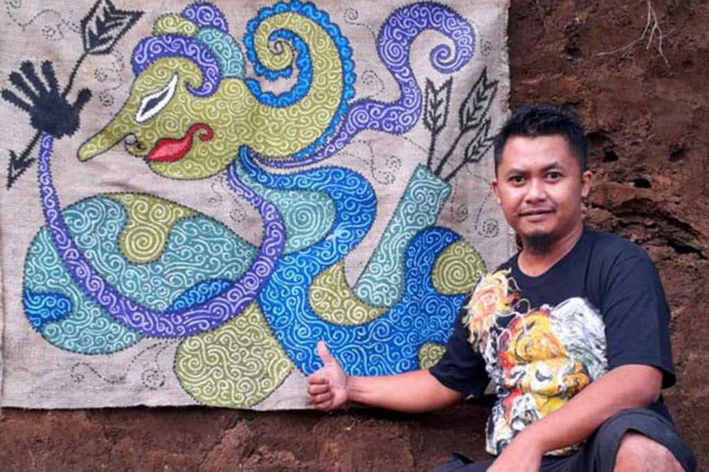Proses melukis seniman di media karung goni. (ist) - Manfaatkan Limbah Karung Goni Sebagai Media Lukis
