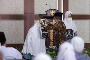 : Wawali Batu mengalungkan tas Identitas Jamaah Haji Batu kepada perwakilan Jamaah. (ist).