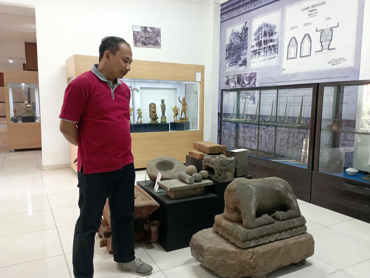 Yossi yang menunjukan salah satu peninggalan sejarah. (ist) - Setelah Dua Tahun Sepi, Museum Singhasari Mulai Kembali Banyak Pengunjung