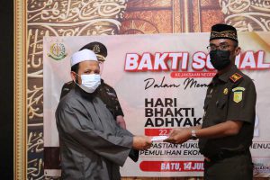 Kajari Batu, Agus Rujito menyerahkan bantuan pada pengasuh Panti Asuhan Al-Manhaal. (ist) - Hari Bhakti Adhyaksa ke-62, Kejari Batu Baksos