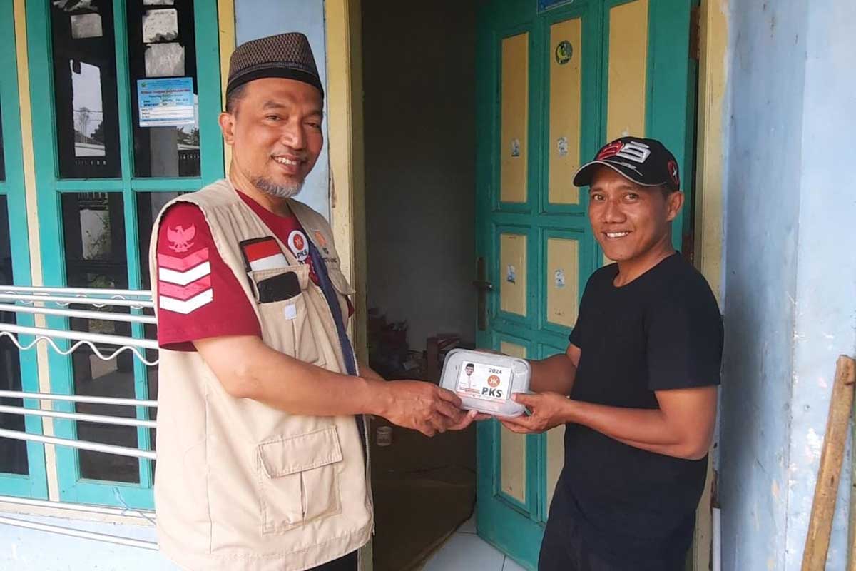 Ketua DPD PKS Kota Malang, Ernanto Djoko Purnomo, membagikan paket kurban. (ist) - DPD PKS Kota Malang Tebar 14.000 Paket Kurban