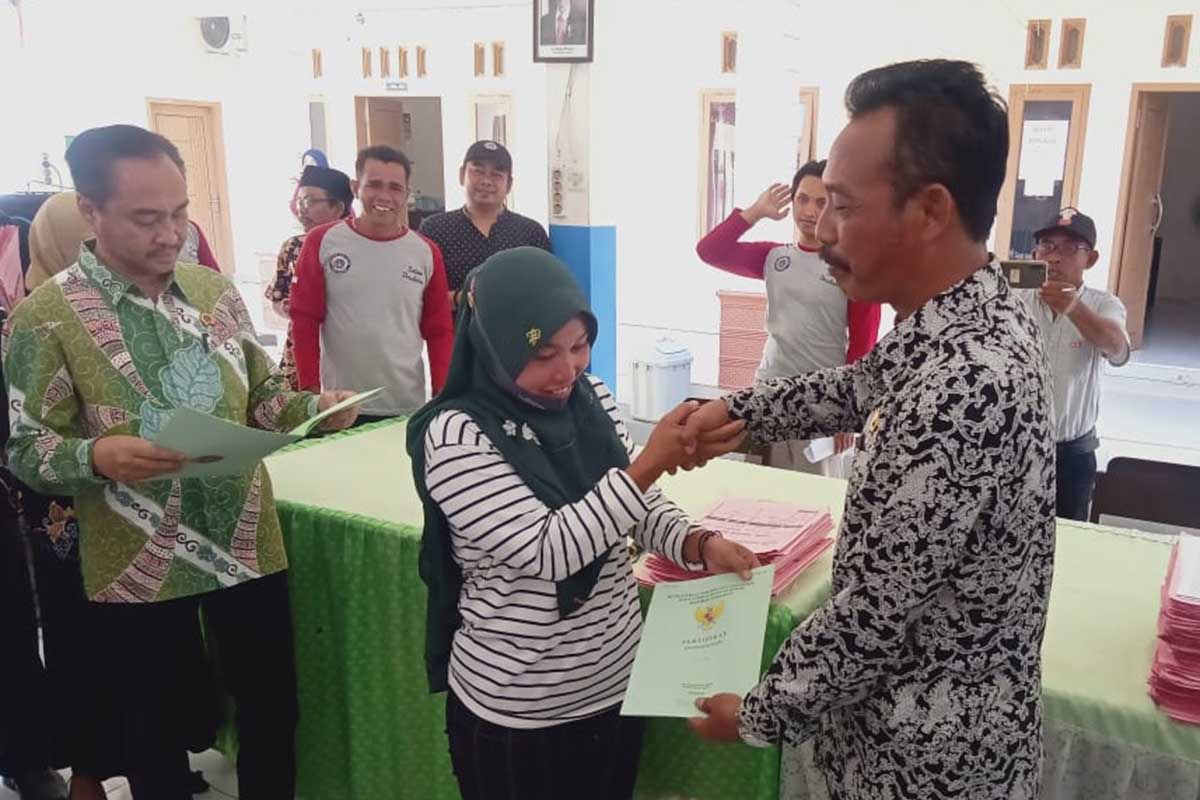 Penyerahan sertifikat melalui Program Pendaftaran Tanah Sistematis Lengkap (PTSL) di Kantor Desa Tugusari. (yas) - Lewat PTSL, 115 Sertifikat Tanah Dibagikan Kepada Warga Tugusari