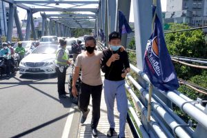 Anggota Polsek Lowokwaru, ketika berhasil membujuk dan menggagalkan percobaan bunuh diri di Jembatan Suhat. (ist) - Aksi Percobaan Bunuh Diri Remaja di Jembatan Sulfat Berhasil Digagalkan Anggota Polsek Lowokwaru