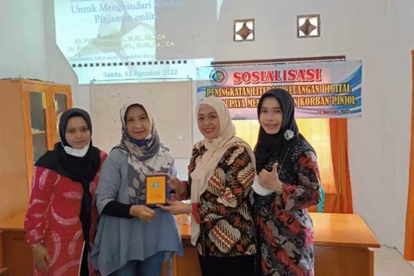 Dosen Akuntansi, Puji Handayati, memberikan cinderamata kepada peserta sosialisasi, usai kegiatan. (ist) - Dosen Akuntansi UM Berikan Literasi Keuangan Digital, Minimalisir Korban Pinjol
