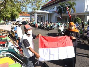Gubernur Jawa Timur Khofifah Indar Parawansa membagikan bendera merah putih kepada 225 tukang becak - Semarak Peringatan HUT RI, Gubernur Khofifah Berbagi Bendera Merah Putih pada Ratusan Tukang Becak