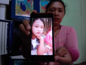 ibu rita menunjukan foto anaknya. ws6