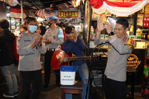 Kapolres Batu AKBP Oskar Syamsuddin SIK MT hibur pengunjung di Sentra Kuliner Alun-alun Batu. (ist) - Sambang Dulur PKL, Kapolres Batu Hibur Pengunjung Alun-alun dengan Lagu