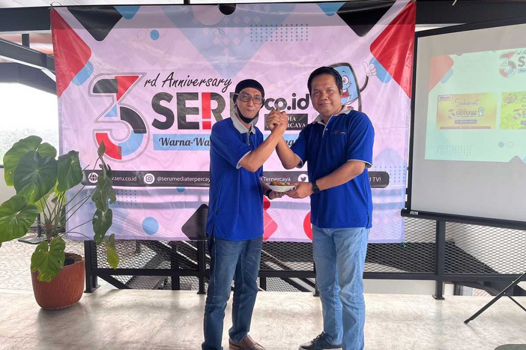Penyerahan simbolis potongan tumpeng dari CEO Memo X Group kepada Direktur SERU.co.id. (tim) - Tiga Tahun Warna-warni Keseruan Perjalanan SERU.co.id