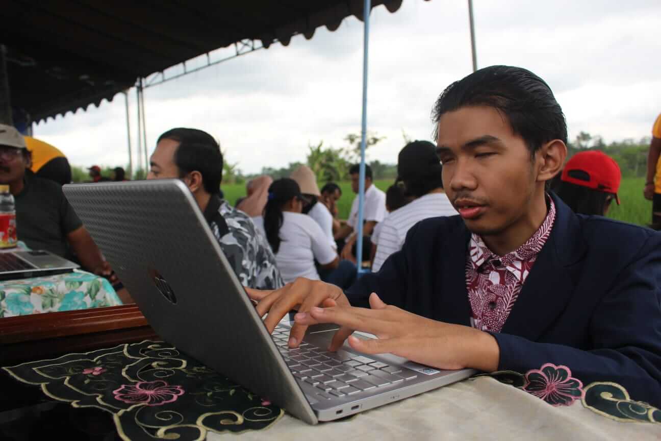 rizal tengah mengoperasikan laptop miliknya