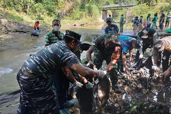 Babinsa Merjosari bersama warga bersihkan sungai Metro. (ist) - Babinsa Merjosari Bersama Warga Bersihkan Sungai Metro