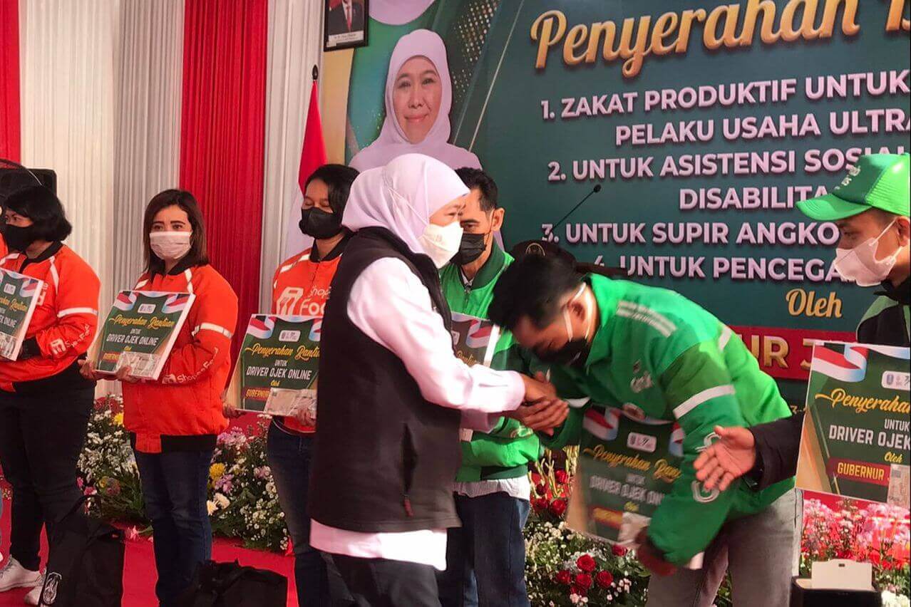 gubernur jawa timur khofifah indar parawansa saat memberikan bansos ke driver ojol dan sopir angkot.